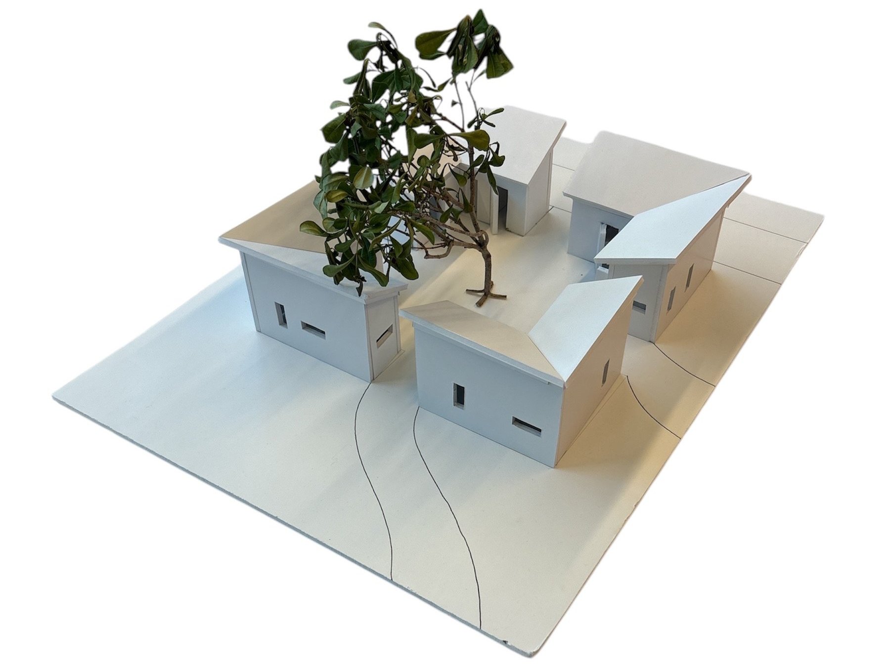 White model of the meditation space: gabled pavilions arranged around a central tree
