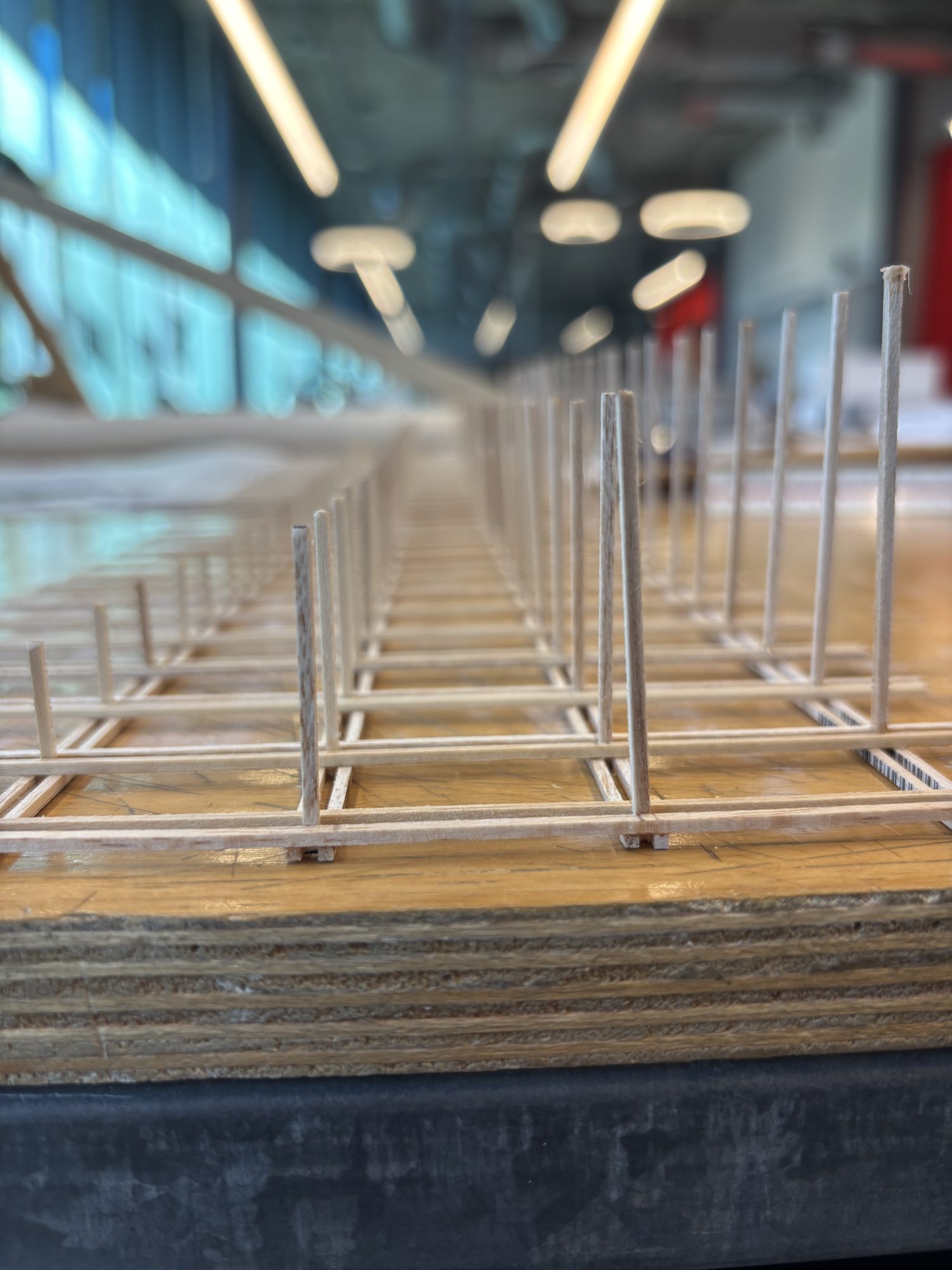 Close-up of a stick-built structural frame model on a plywood base
