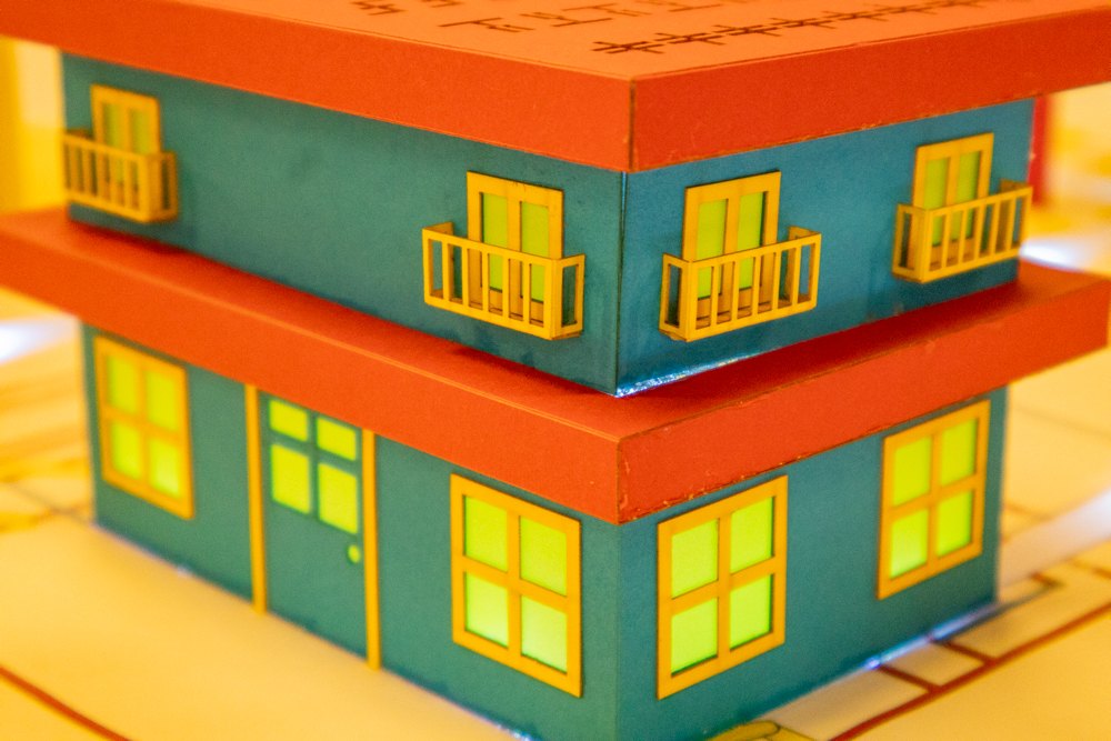 A paper building lit from inside, its windows glowing