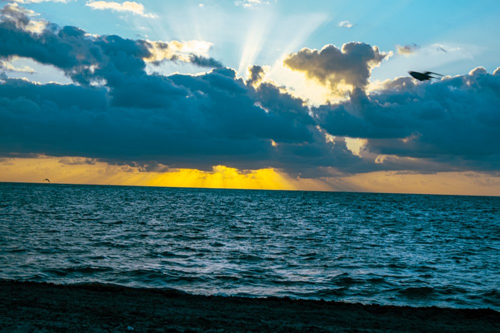 Sun rays breaking through clouds over the ocean